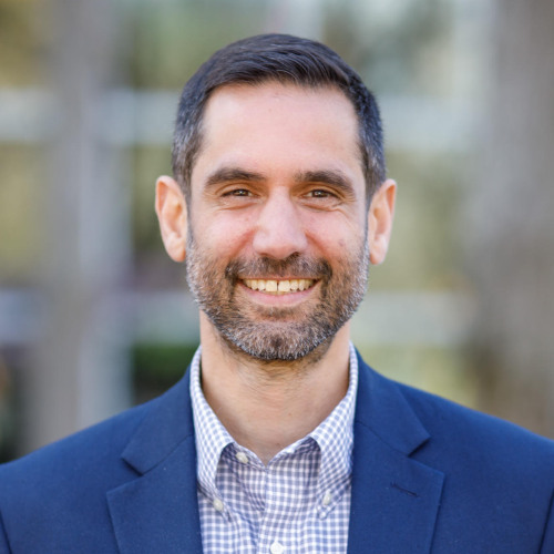 David Williams PhD smiling, blurred trees in background