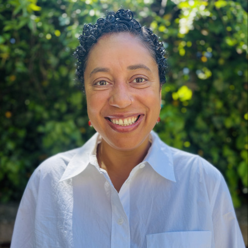 Madina Agénor PhD smiling in front of blurred trees
